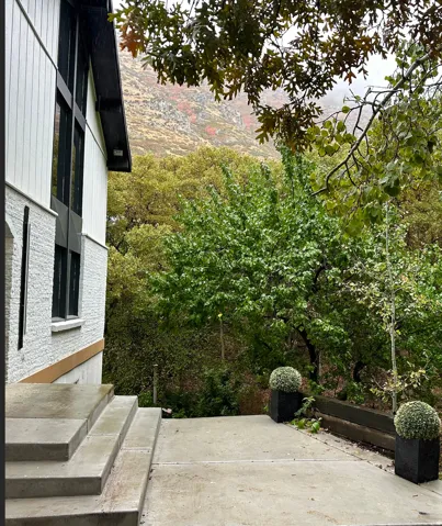 Contemporary exterior featuring white vertical siding, dark-framed windows, and textured white brick accents