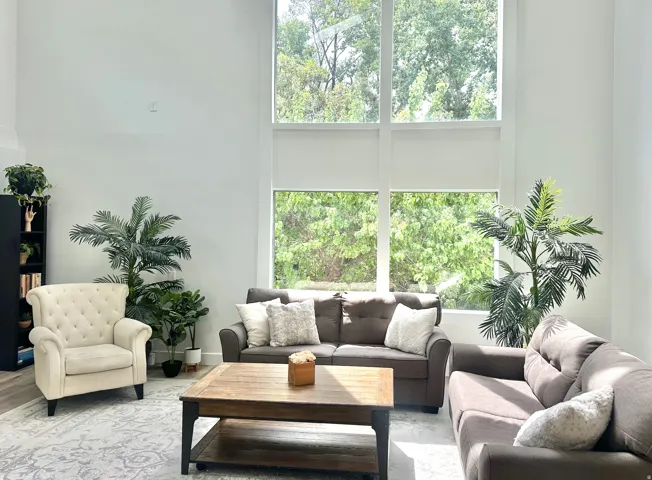Living area featuring double-height ceilings and large-format windows