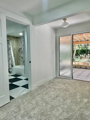 Plush gray carpeting throughout, featuring a gold-toned flush mount light fixture