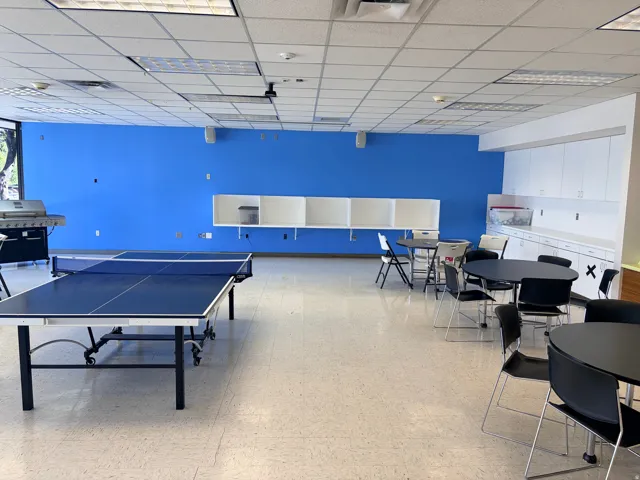 Spacious common area featuring light-toned flooring and a dropped ceiling with integrated lighting