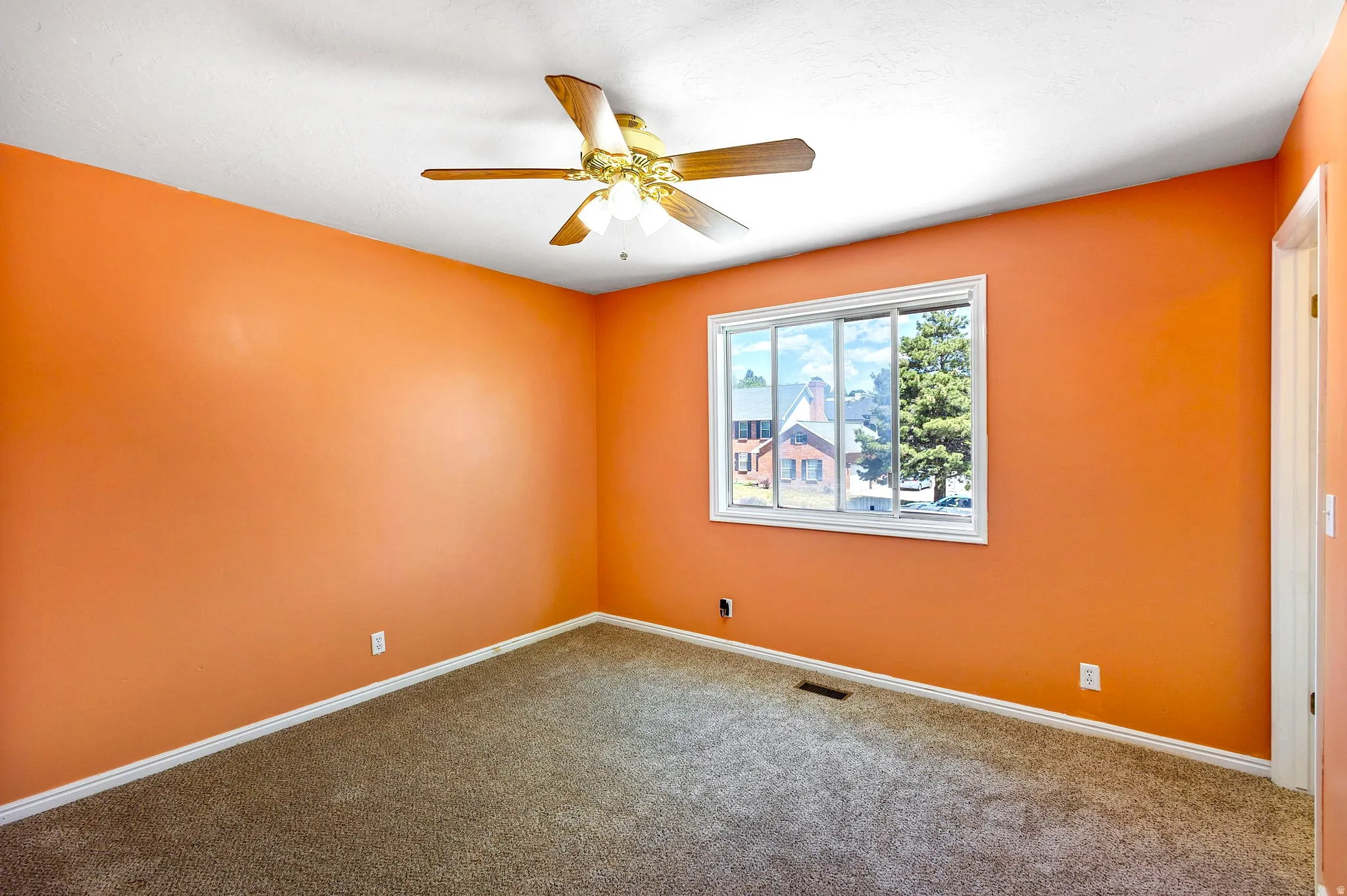 Bedroom #3, Spacious room featuring a large window, textured carpeting, and a ceiling fan with integrated lighting