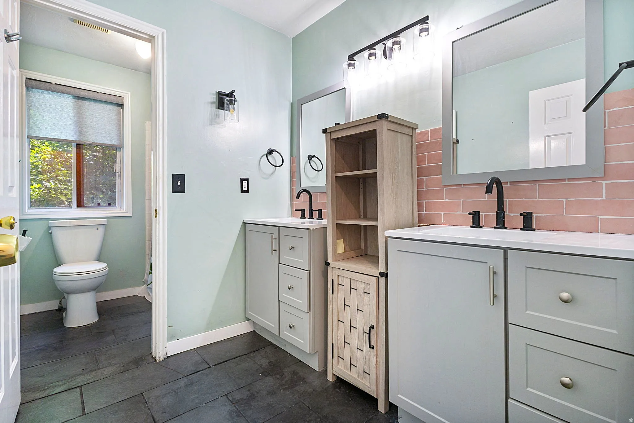 Bathroom featuring dual vanities with light gray cabinetry and white quartz countertops.