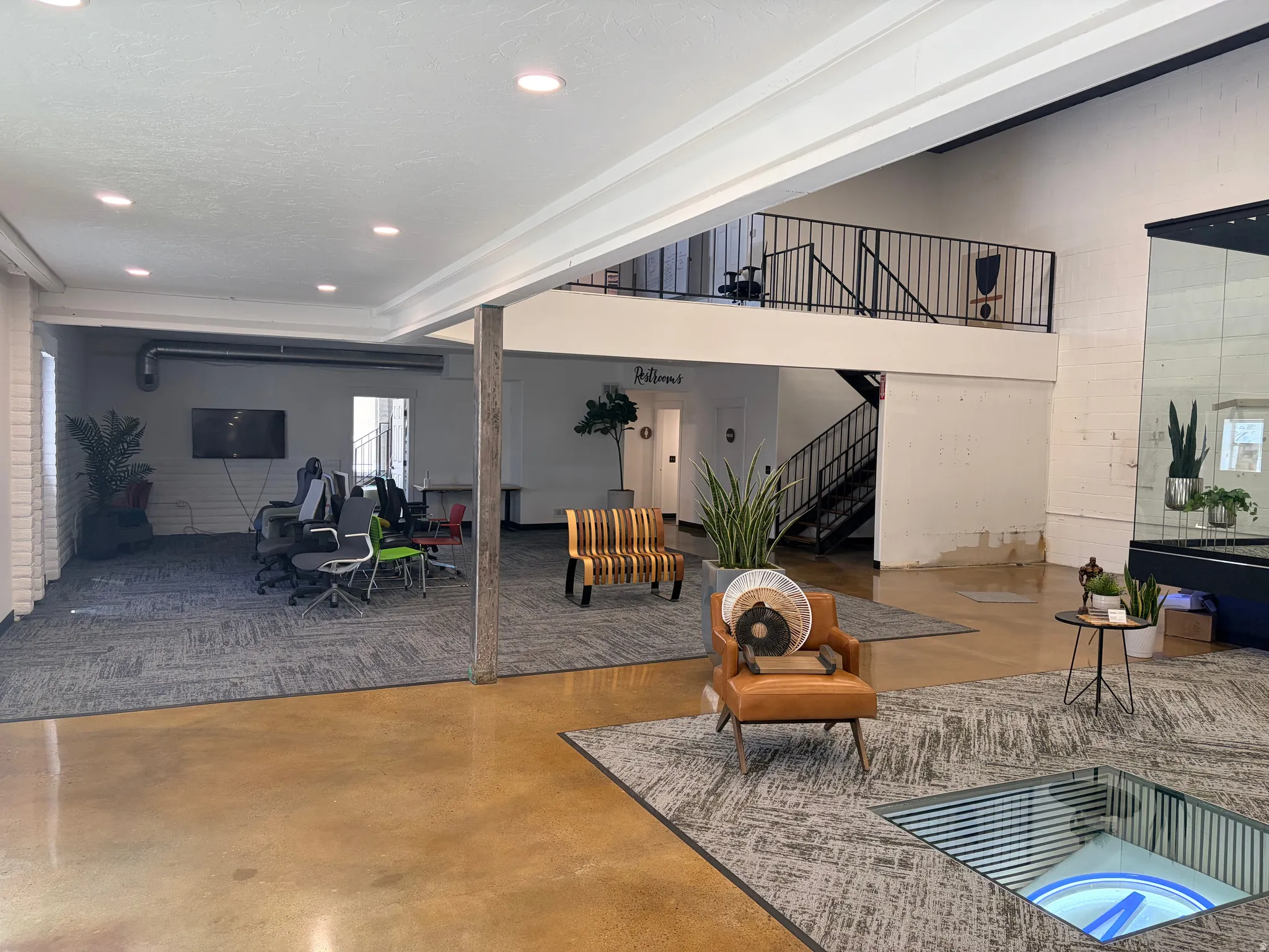 Open-concept interior featuring mixed flooring with polished concrete and patterned carpet