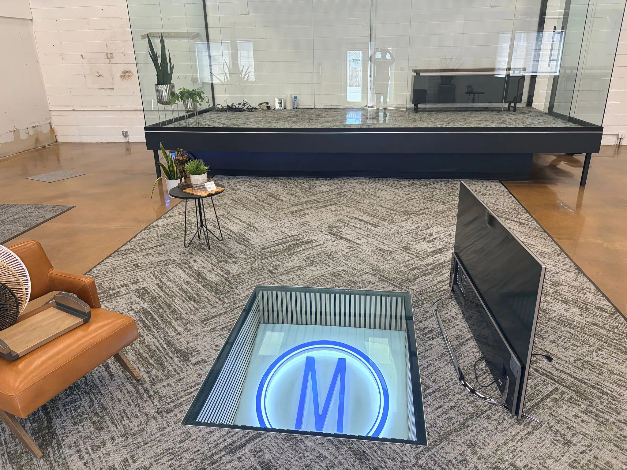 Spacious interior featuring a raised platform with clear glass walls and a polished concrete floor