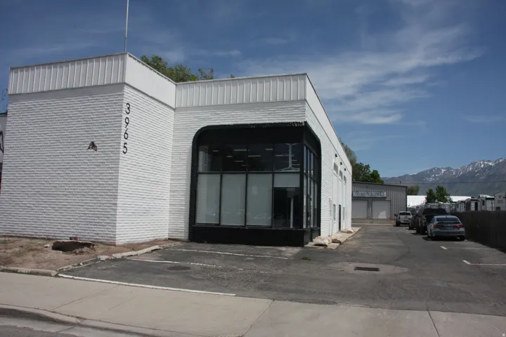 Commercial building with white brick facade and corrugated metal accents
