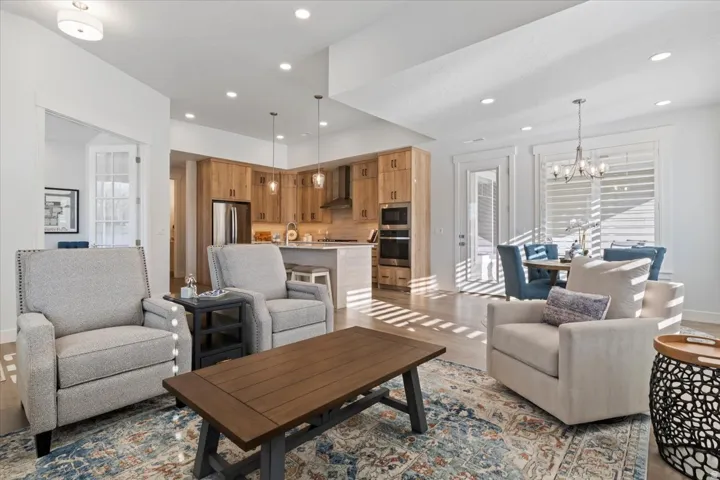 Open-concept living area featuring light wood-finish flooring, recessed lighting, and a kitchen with wood cabinetry