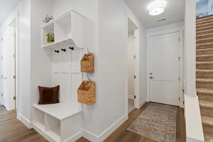 Entryway featuring a built-in bench, storage cubbies, and coat hooks