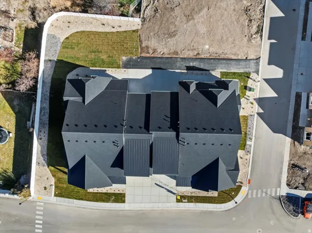 Newly constructed multi-unit residences featuring dark shingle roofing, contemporary architectural lines, and private paved driveways