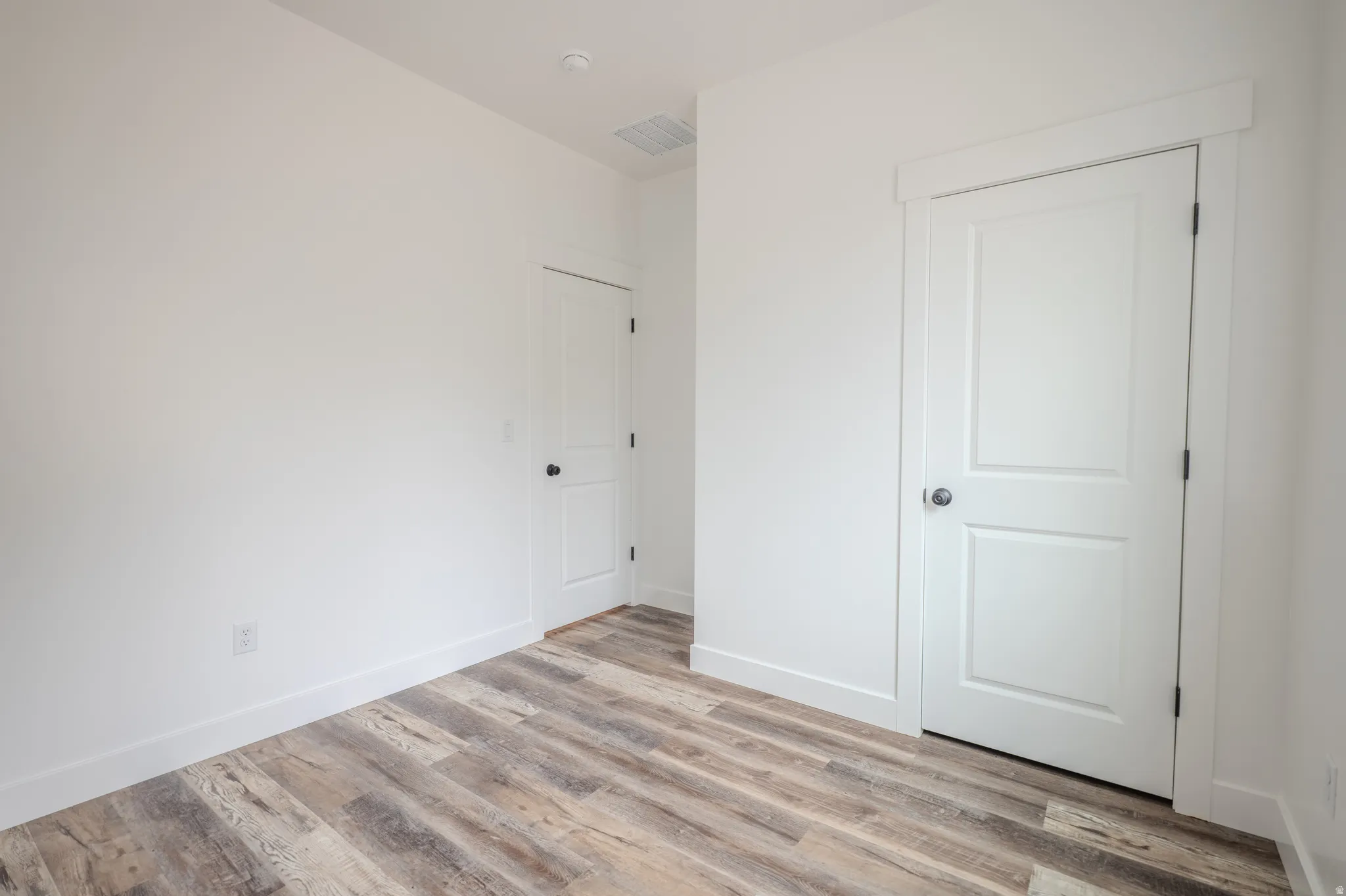 Neutral white walls complement wood-finish flooring
