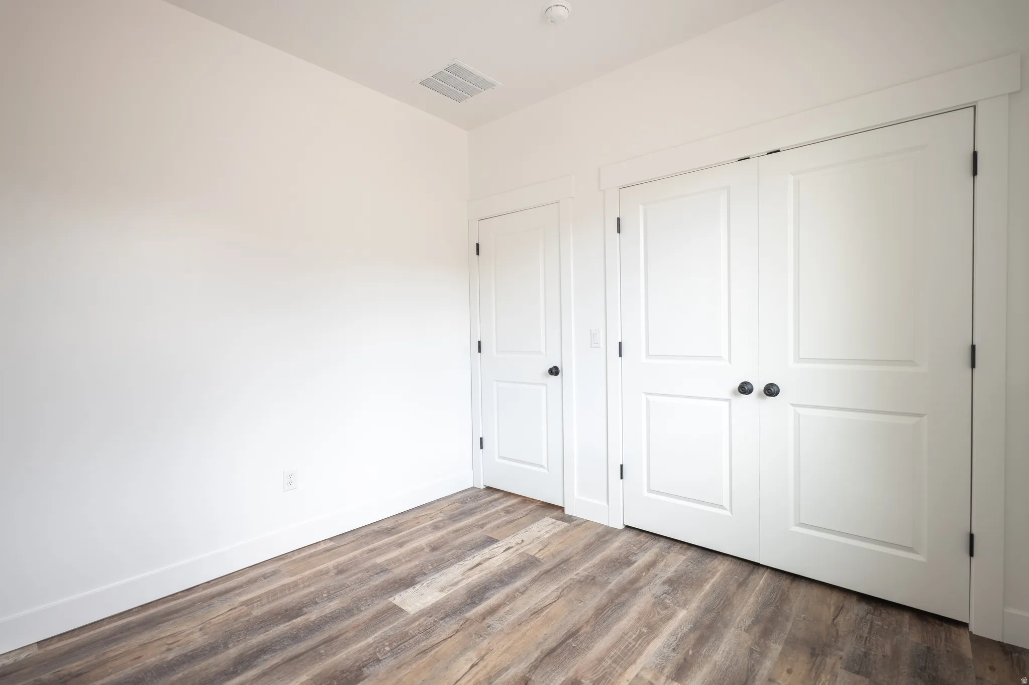 Wood-finish flooring throughout, complemented by white baseboards and white walls