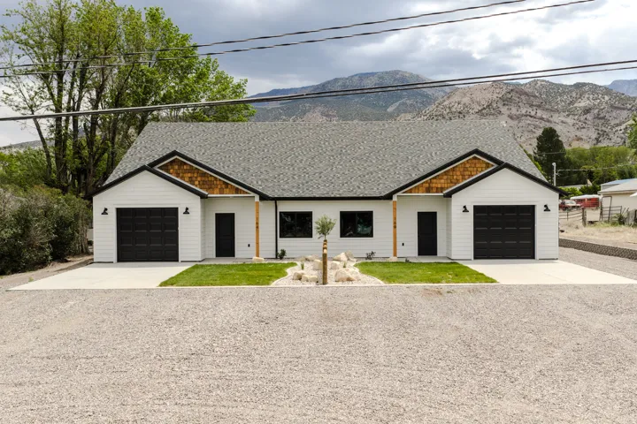 Modern duplex with white horizontal siding and black trim accents