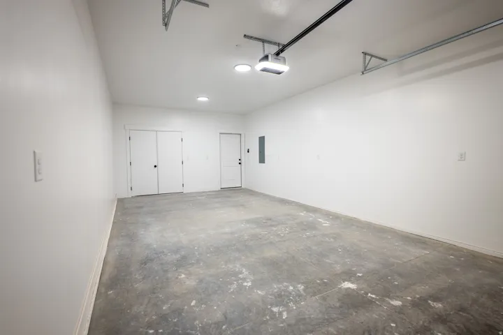Spacious garage featuring a concrete floor, bright white walls, and recessed ceiling lighting