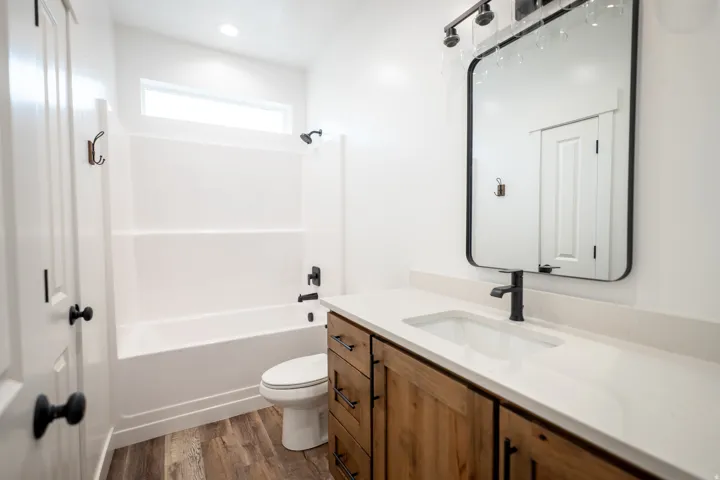 Bathroom featuring a single vanity with wood-finish cabinetry, a light-toned countertop, and an integrated rectangular sink