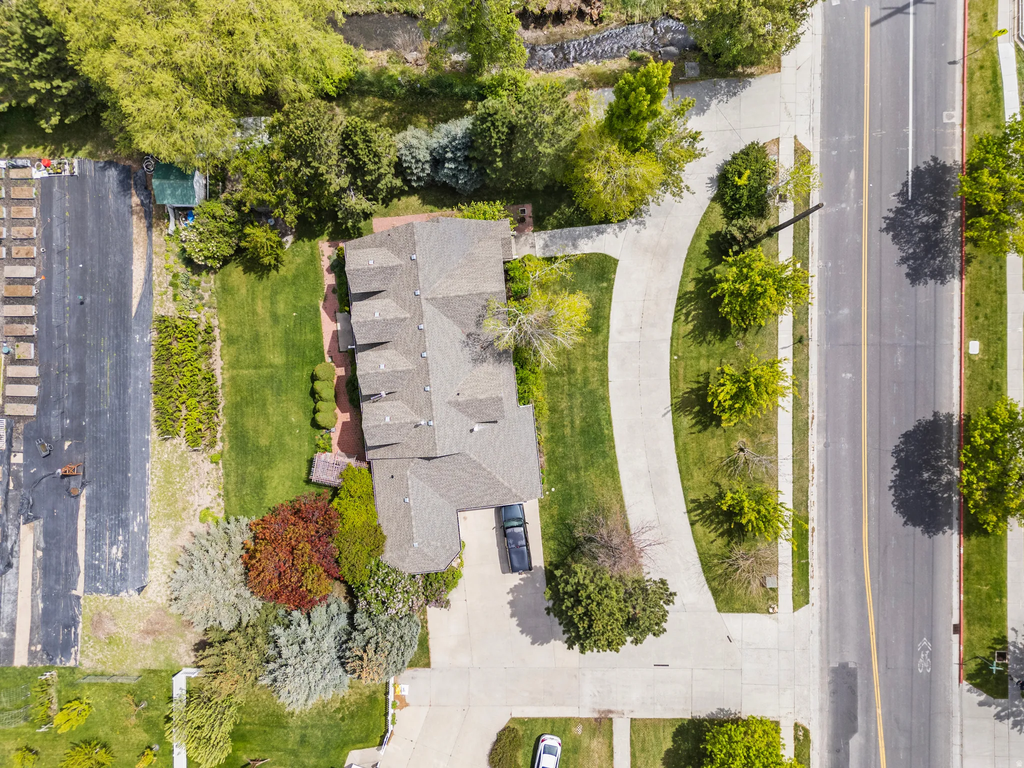 Aerial view highlighting the property's expansive grounds, mature trees, and landscaping