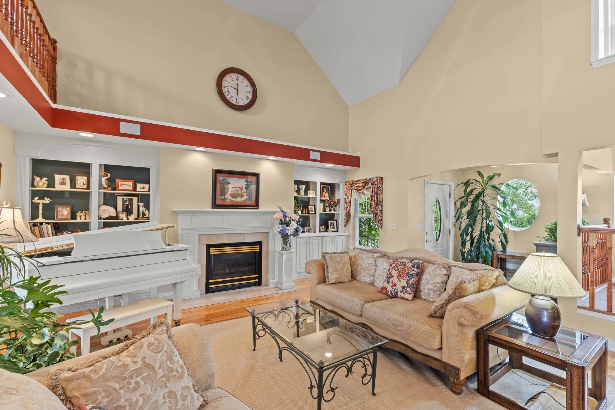 Living area featuring a vaulted ceiling and an upper-level balcony with wood railing