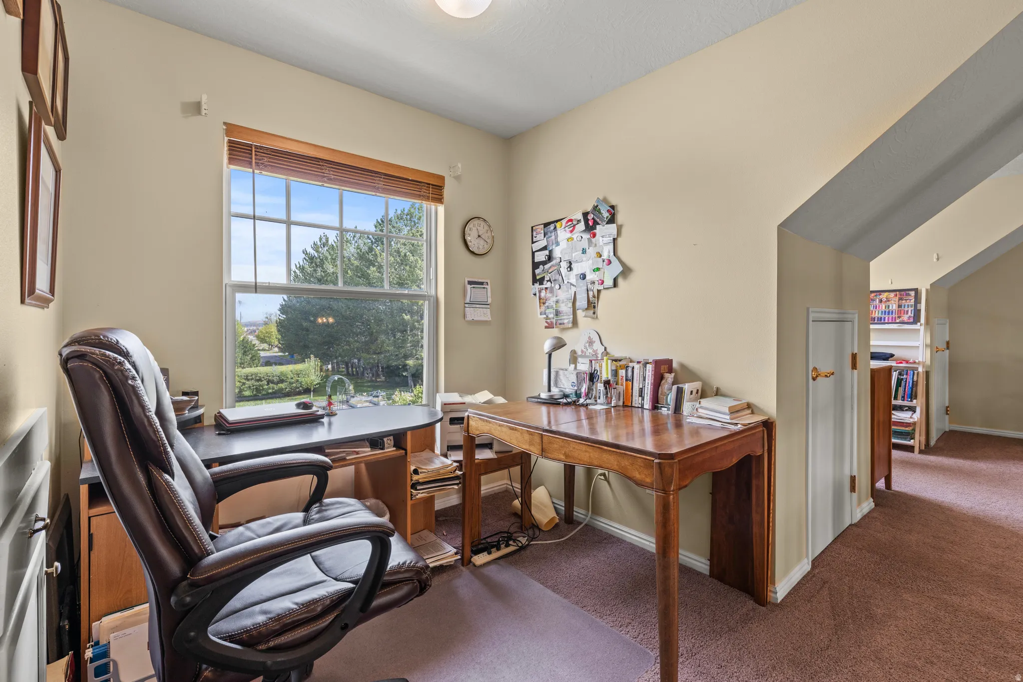 Inviting room featuring a large window, light-toned walls, and a warm carpeted floor