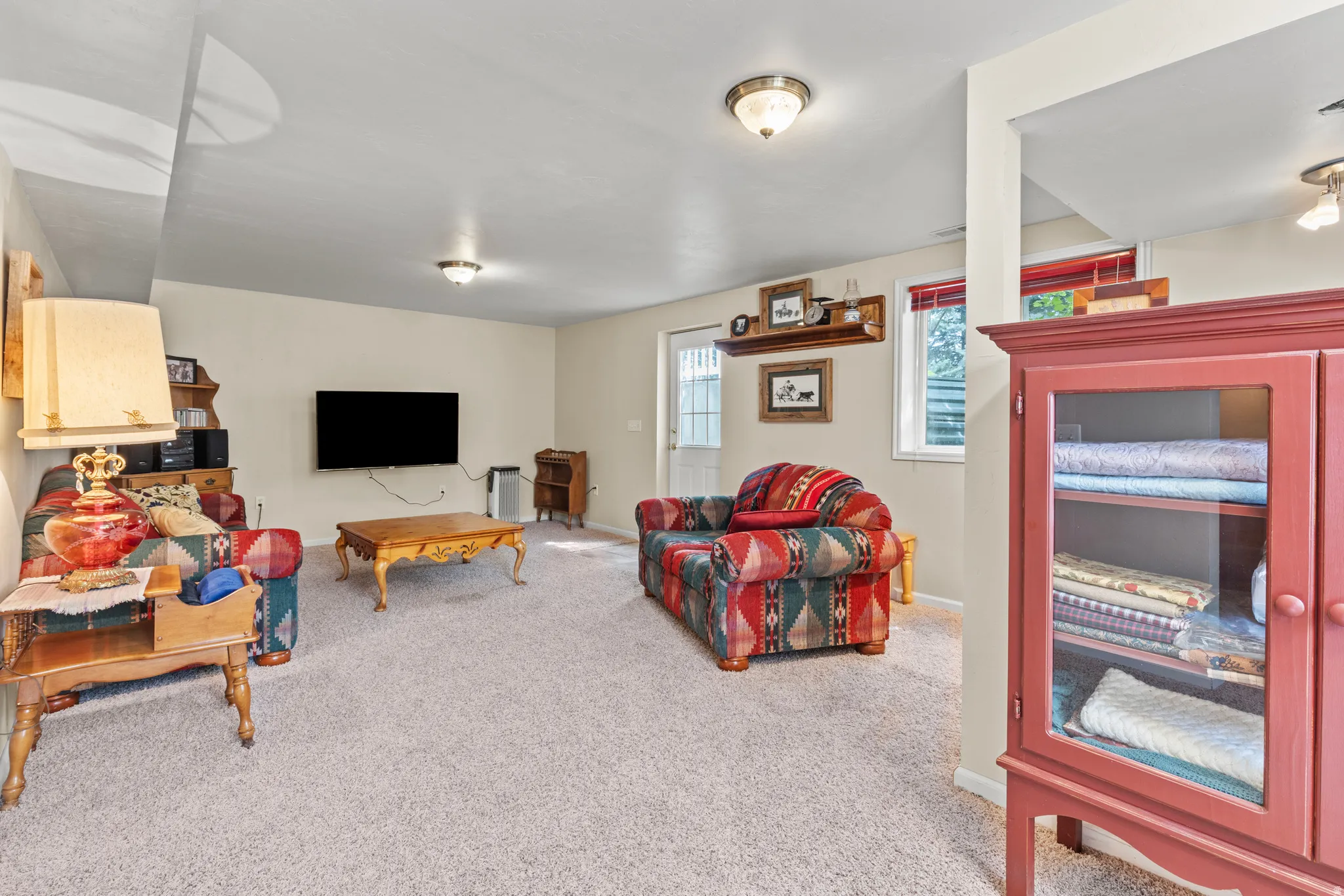 Spacious carpeted room featuring recessed lighting, light-toned walls, and multiple windows with red blinds