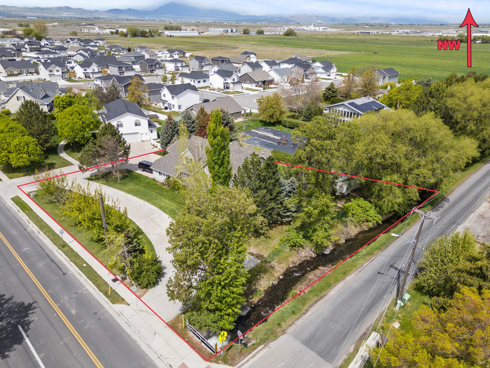 Aerial perspective showcasing a property with a distinct perimeter outlined in red