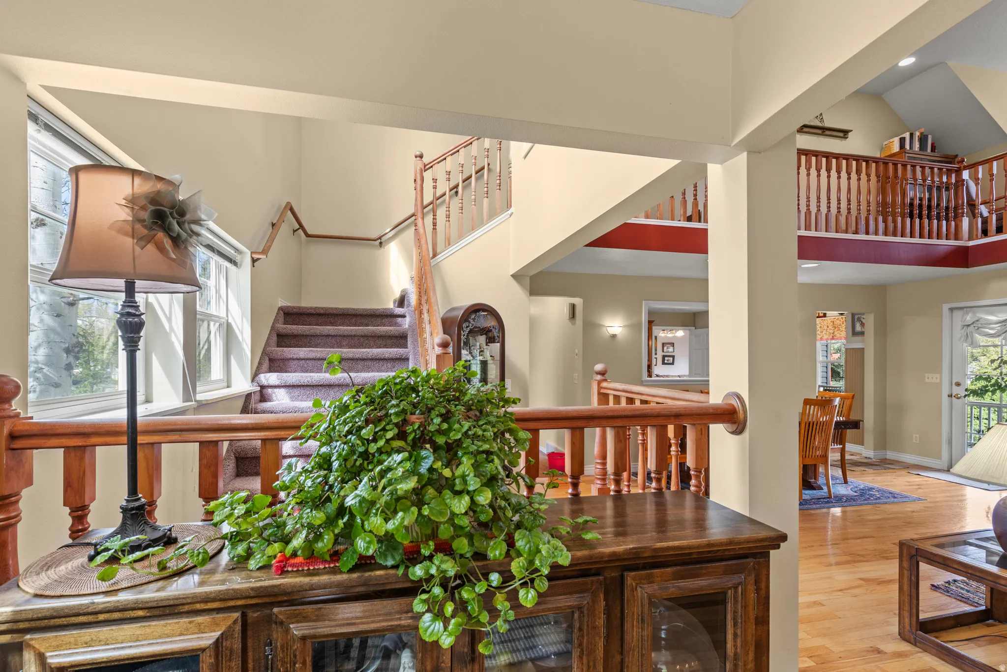 Interior space featuring wood-finish flooring, a wood baluster railing system, and a carpeted staircase