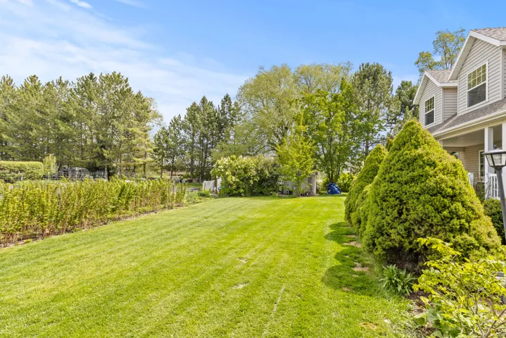 Expansive lawn area with manicured plantings and mature trees