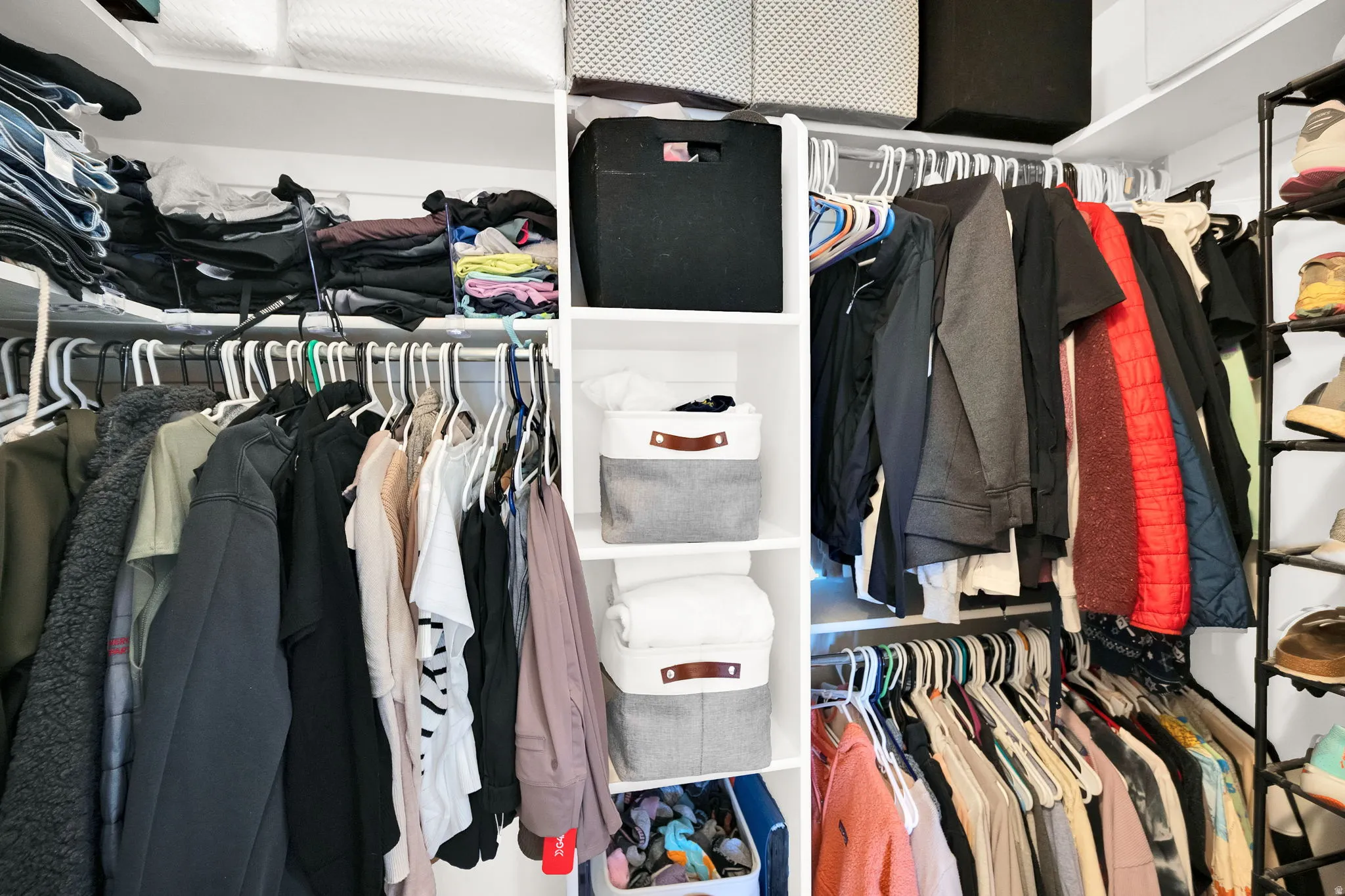 Custom closet system featuring multiple hanging rods, integrated shelving, and dedicated shoe storage