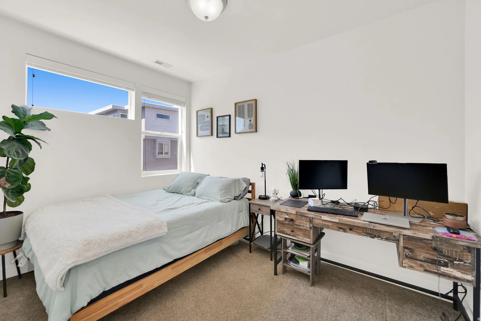 Light-filled interior space with a neutral color palette, featuring expansive windows, recessed lighting, and carpeted flooring
