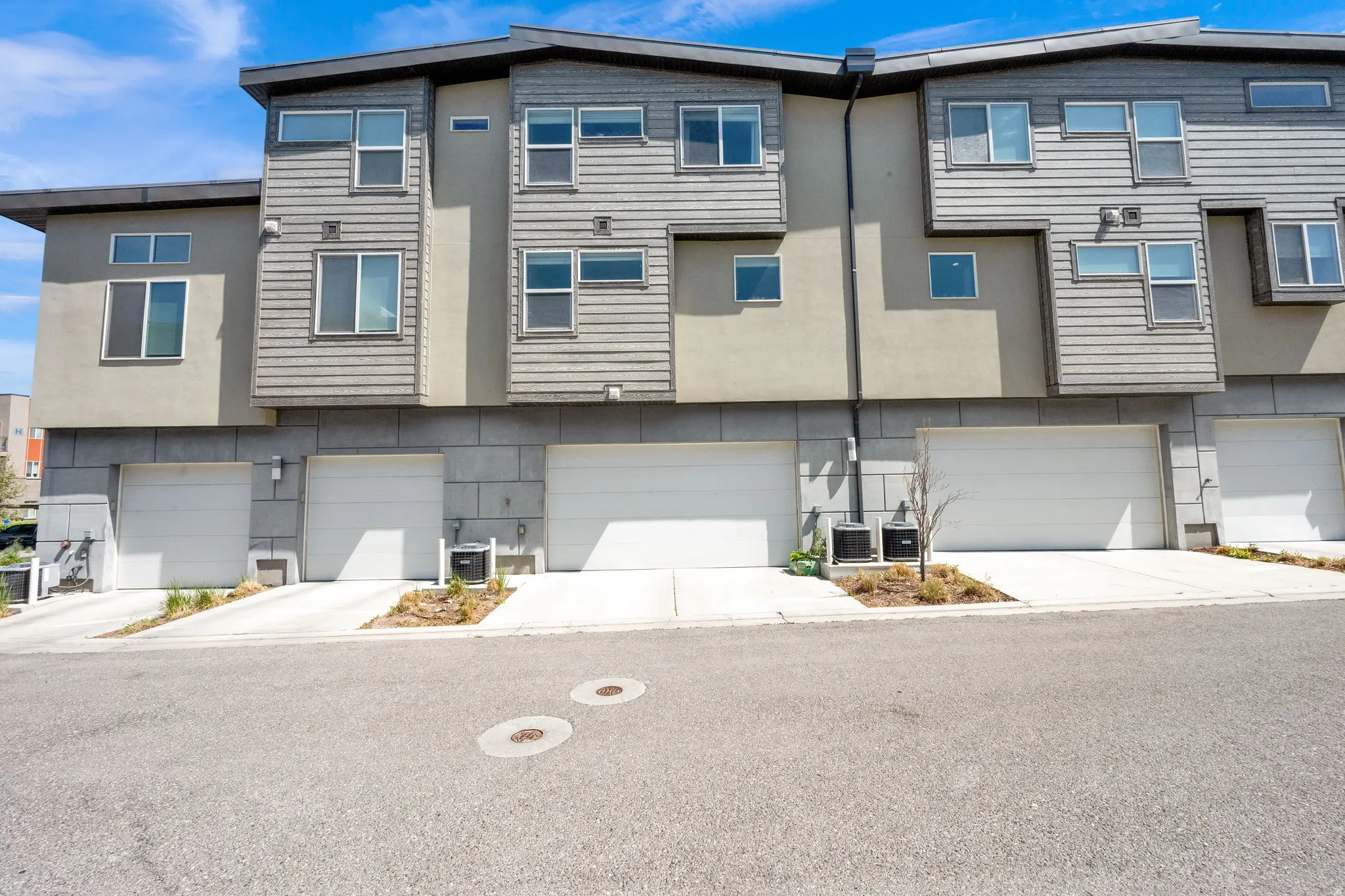 Contemporary multi-level townhome featuring a mix of horizontal siding and stucco finishes