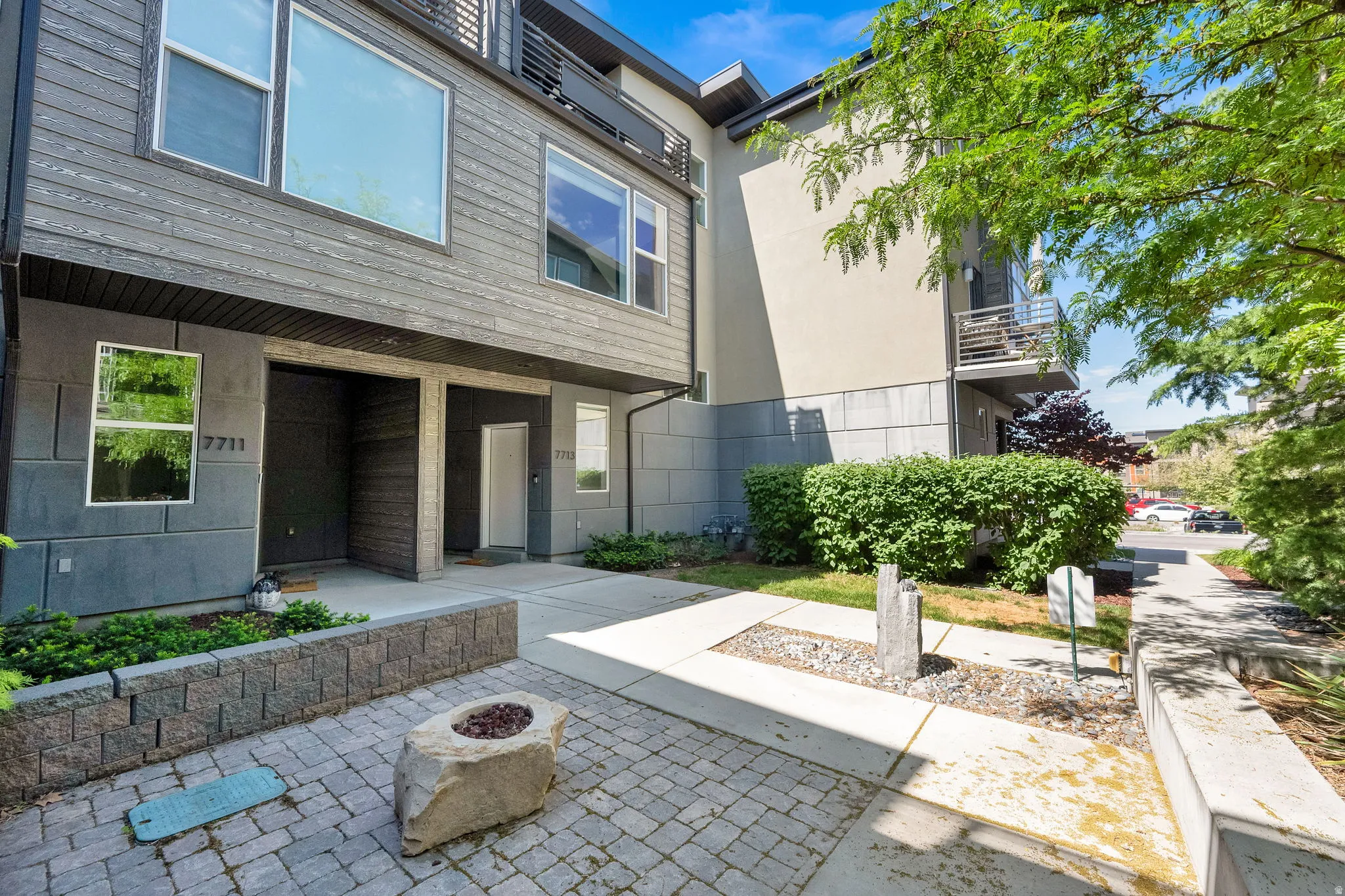 Modern multi-level exterior featuring dark horizontal siding and a light stucco finish