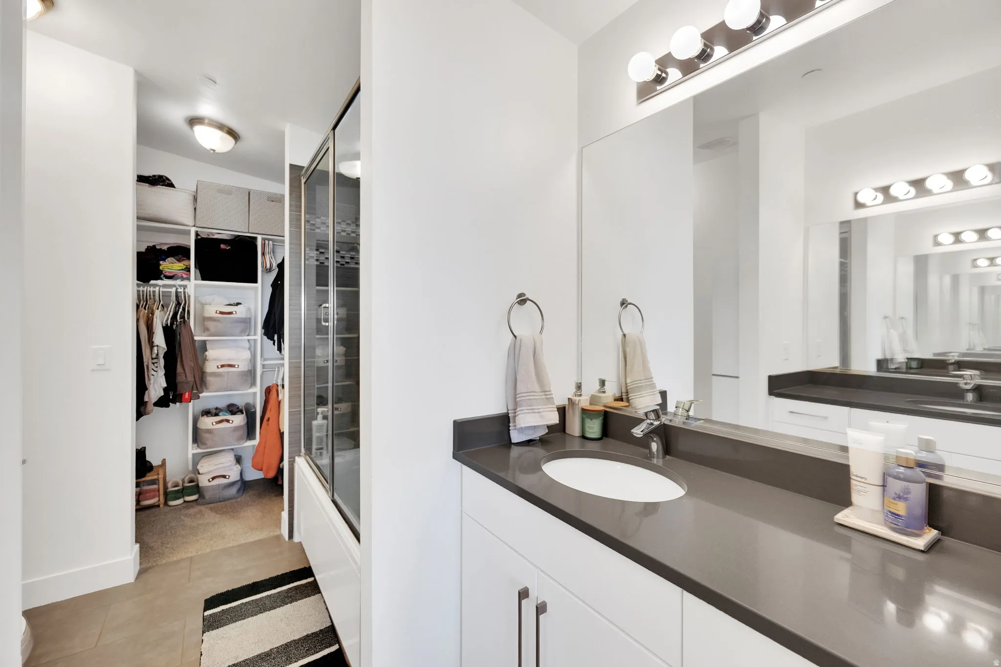 Modern bathroom vanity featuring an integrated sink, dark countertop, and chrome faucet