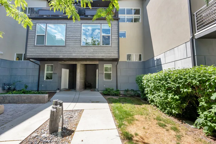 Modern townhome exterior with mixed material facade, featuring horizontal siding and paneling
