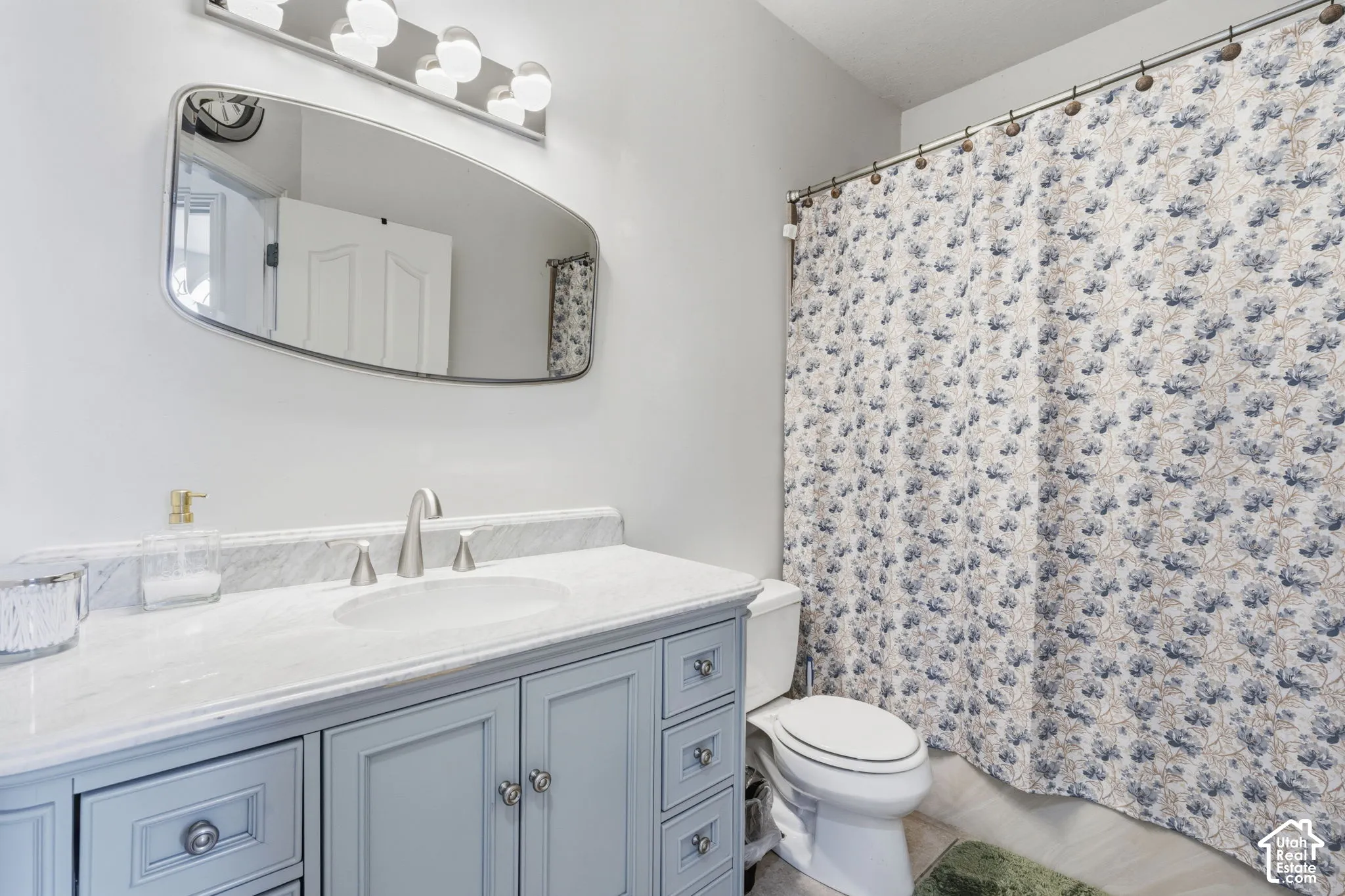 Vanity with light blue cabinetry, dual-handle faucet, and an oval undermount sink