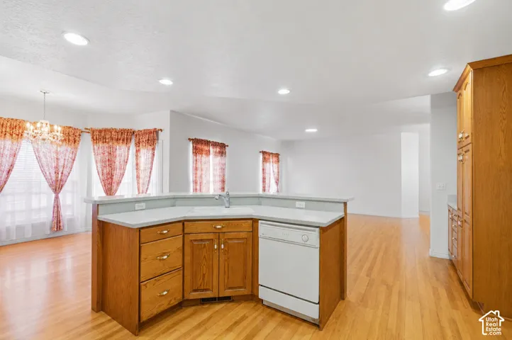 Wood-finish flooring throughout, recessed lighting, and a kitchen island with integrated sink