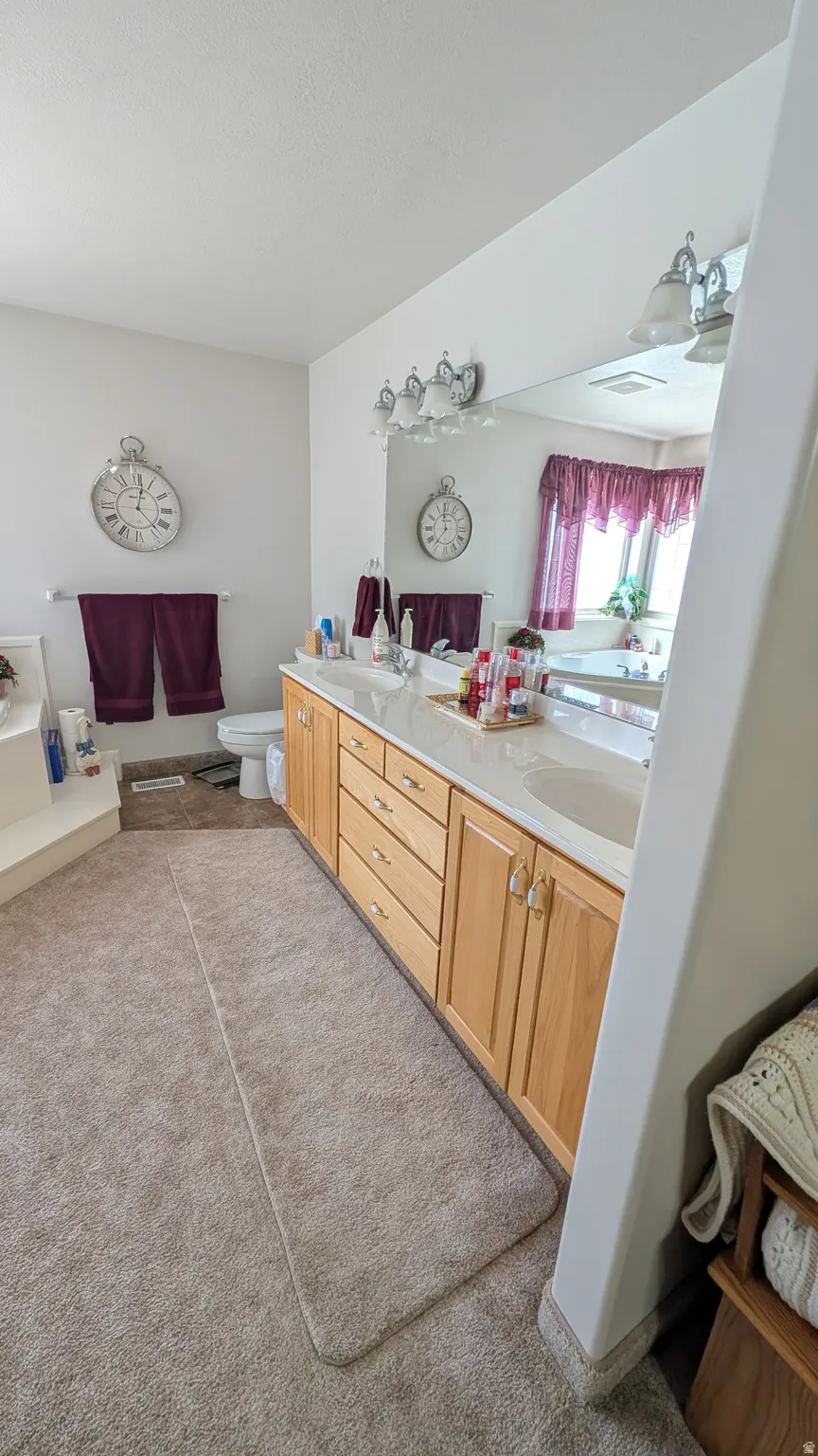 Double vanity with wood-finish cabinetry, integrated sinks, and polished hardware