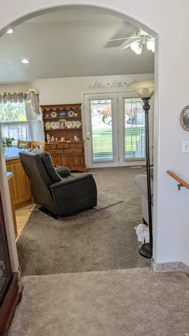 Archway entry framing a living space with plush carpet flooring
