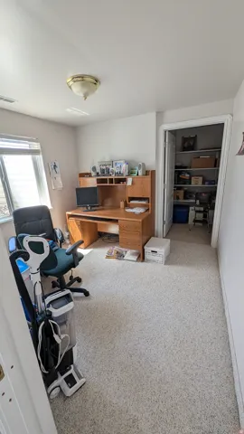 Carpeted room featuring a ceiling-mounted light fixture and a window with blinds