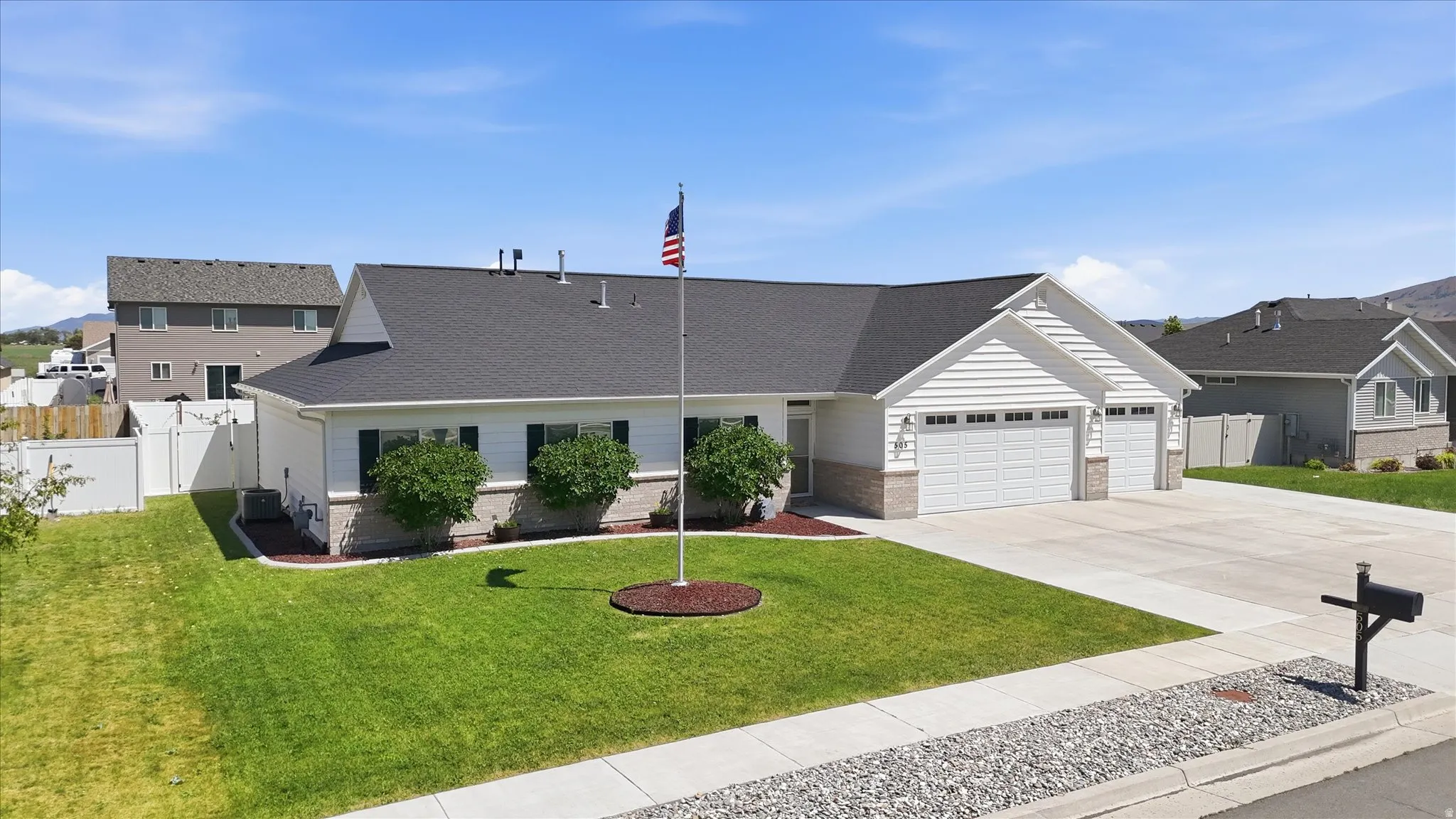 Ranch-style residence featuring white siding, a dark shingle roof, and stone facade accents