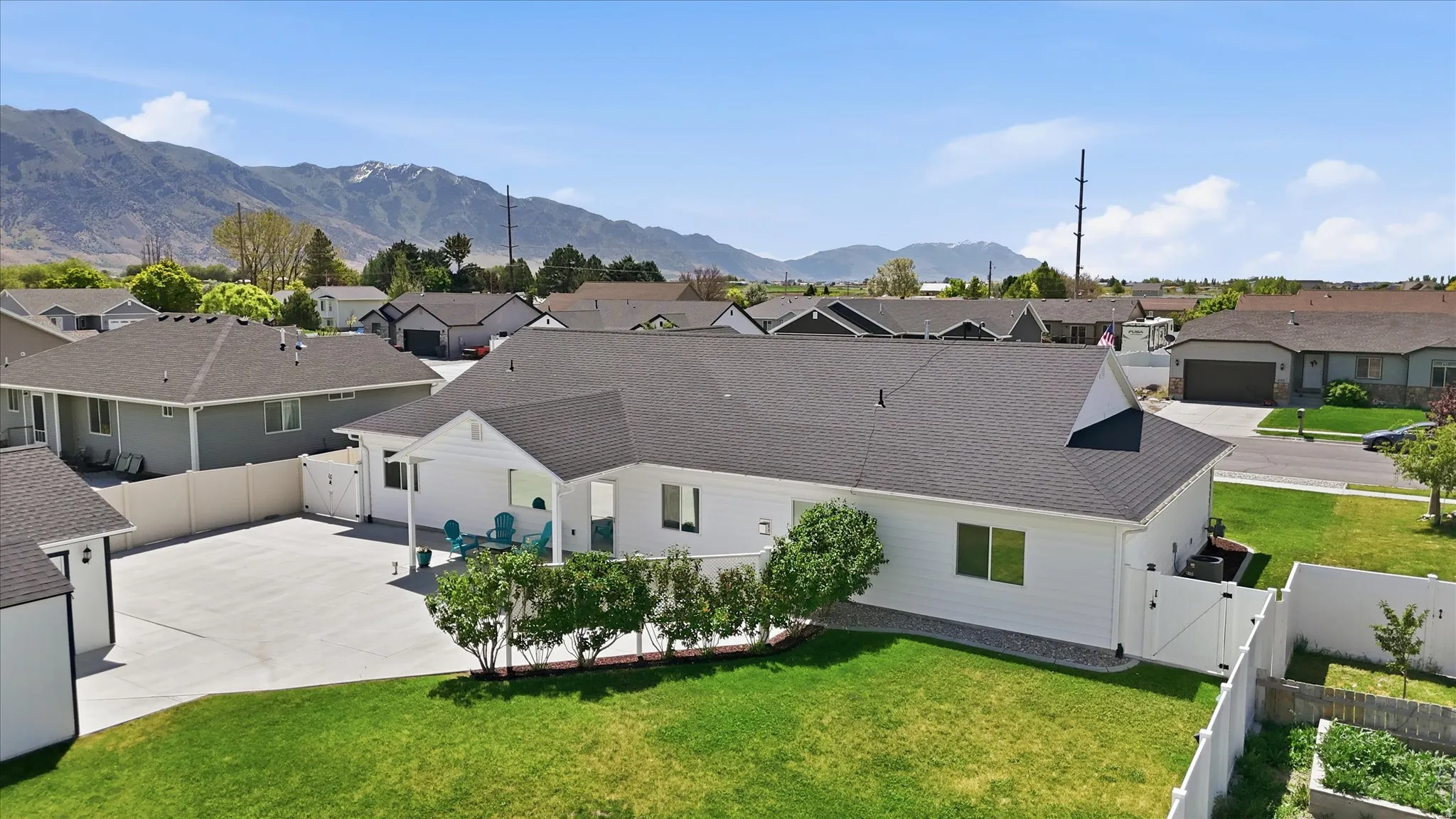 White exterior residence with a dark shingle roof and a covered patio