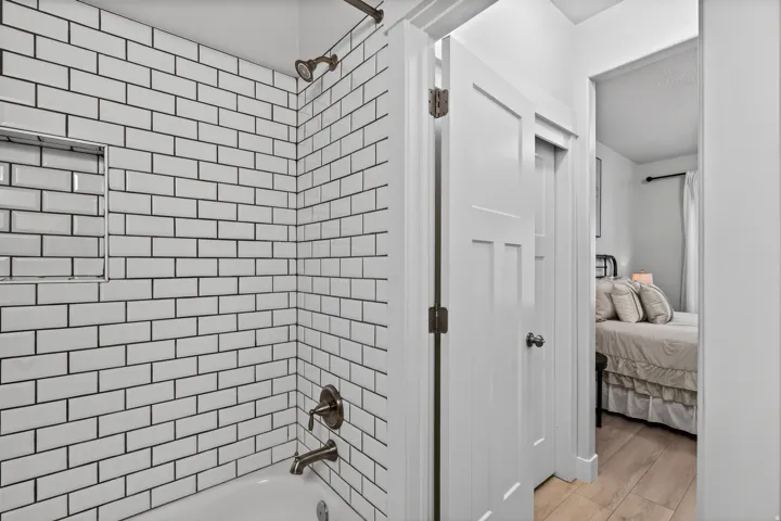White subway tile shower surround with a built-in niche and bronze-finish fixtures