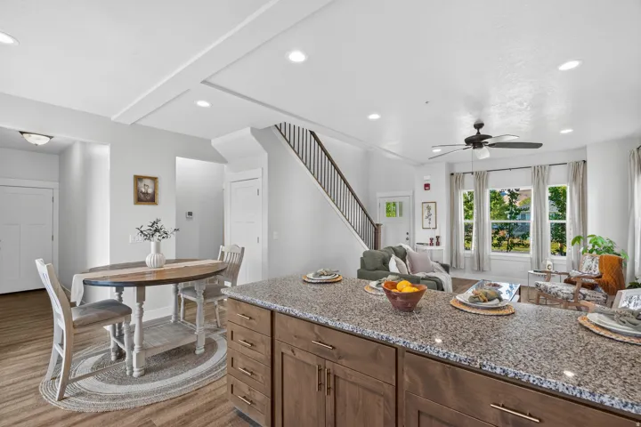 Kitchen island featuring a granite-style countertop and wood-finish cabinetry with brass hardware