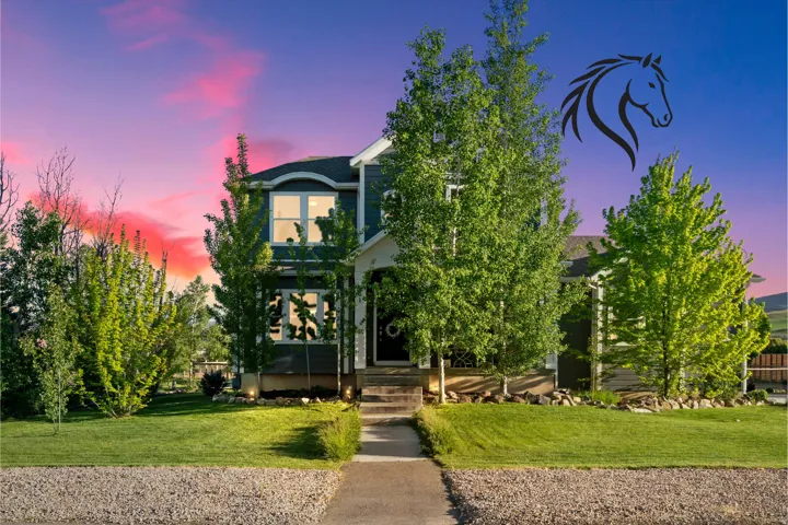 Two-story residence featuring a dark siding exterior, white trim, and a covered front porch