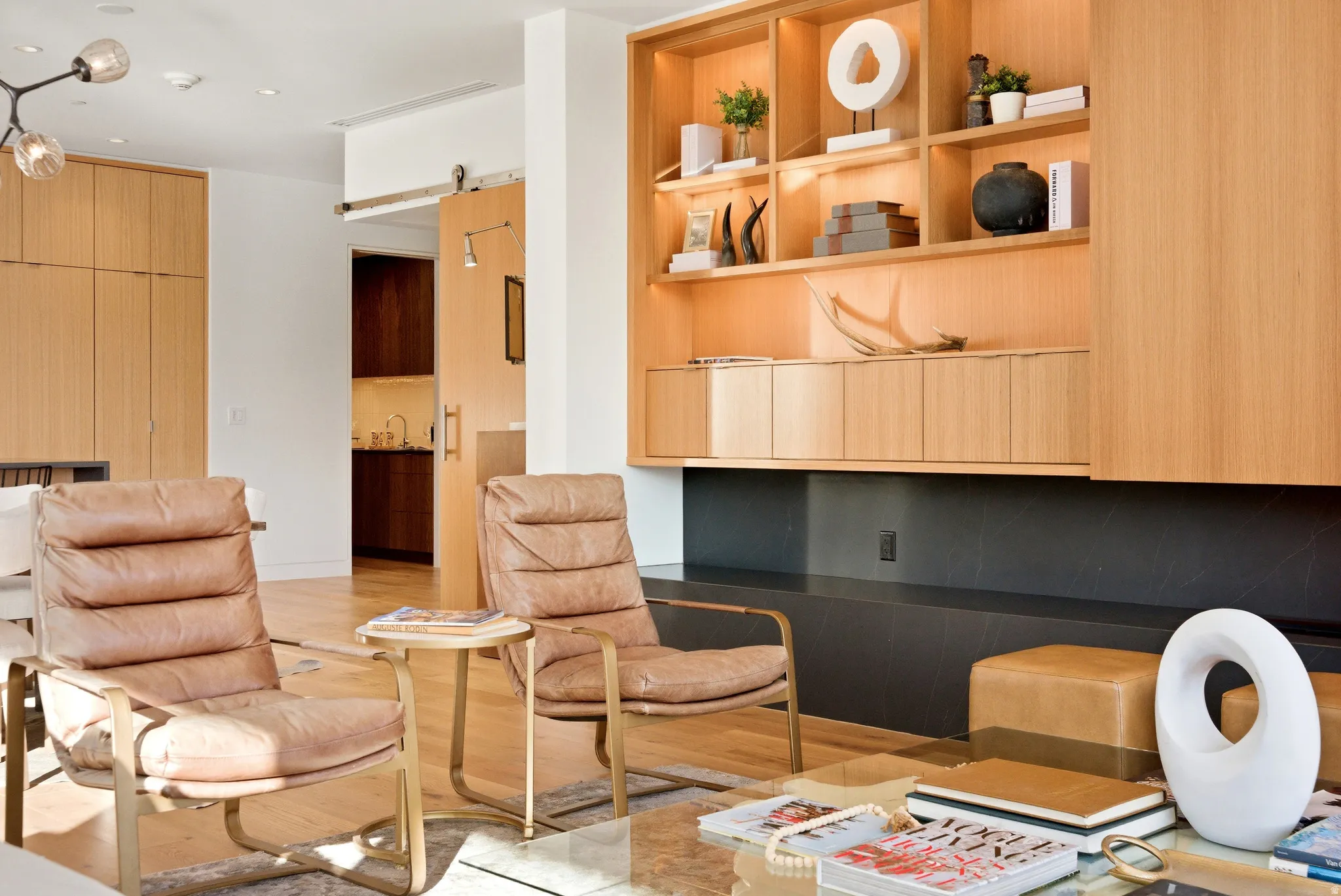 Integrated wood-finish shelving and cabinetry with ambient lighting over a dark stone-finish hearth