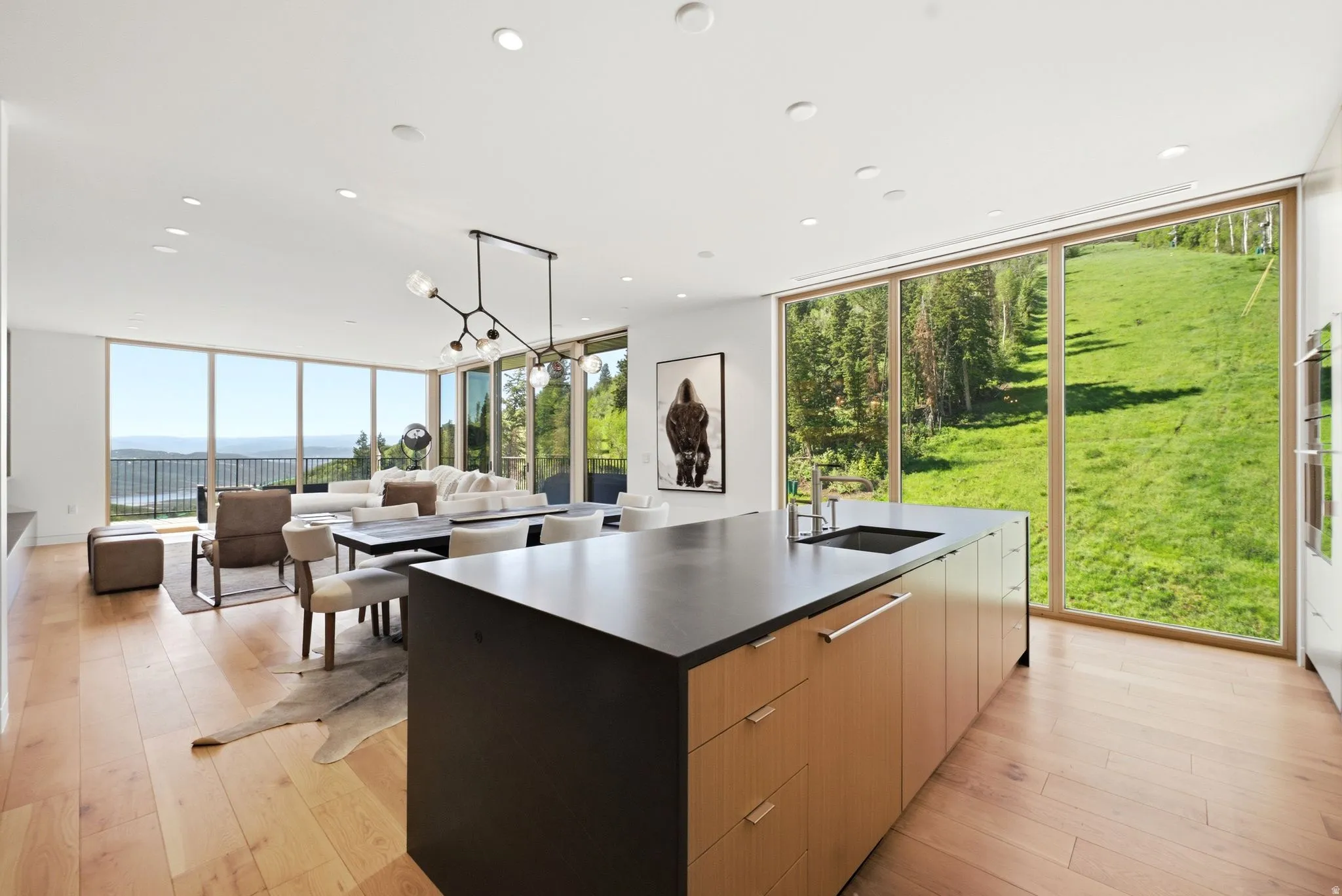 Open-concept living space featuring wood-finish flooring and extensive floor-to-ceiling windows