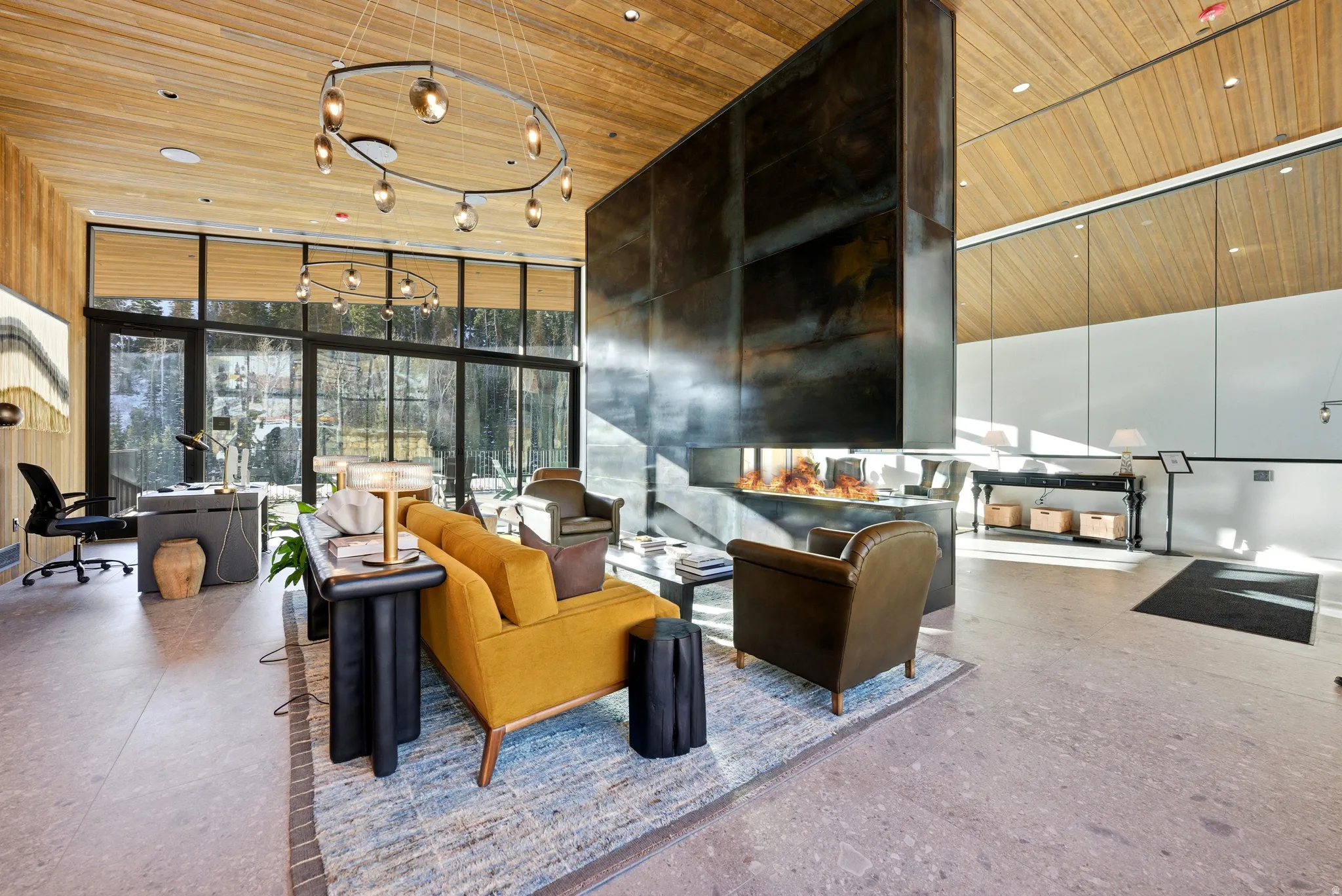 Spacious room featuring a floating fireplace, wood plank ceiling, and large format tile flooring