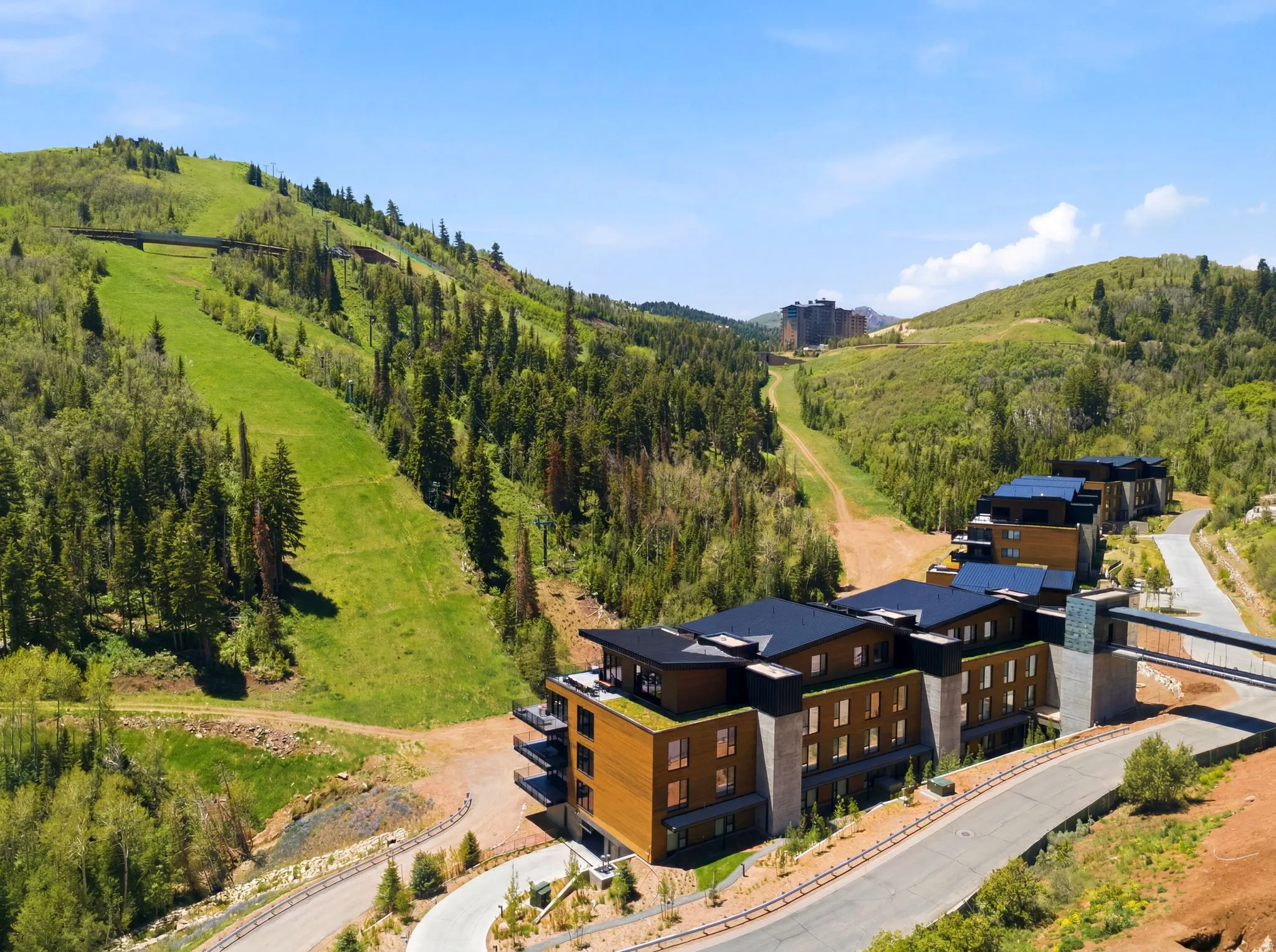 Contemporary mountain-side architecture featuring wood-paneled facades and dark-pitched roofs