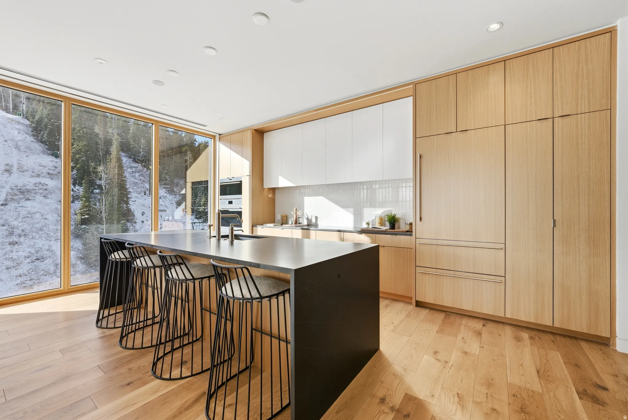 Kitchen with a large island featuring a built-in sink and seating