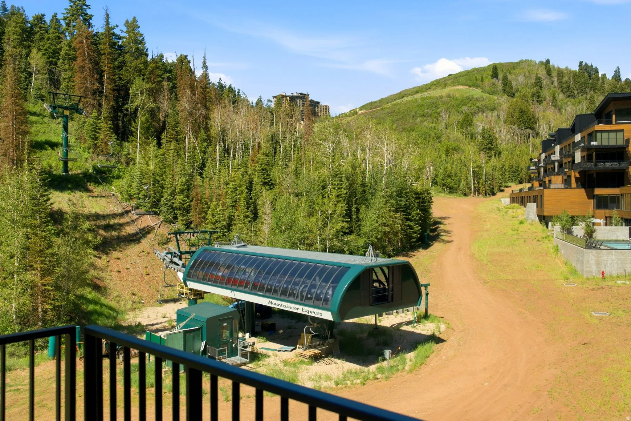 Mountainous landscape featuring a ski lift and multi-story structures with wood-paneled exteriors