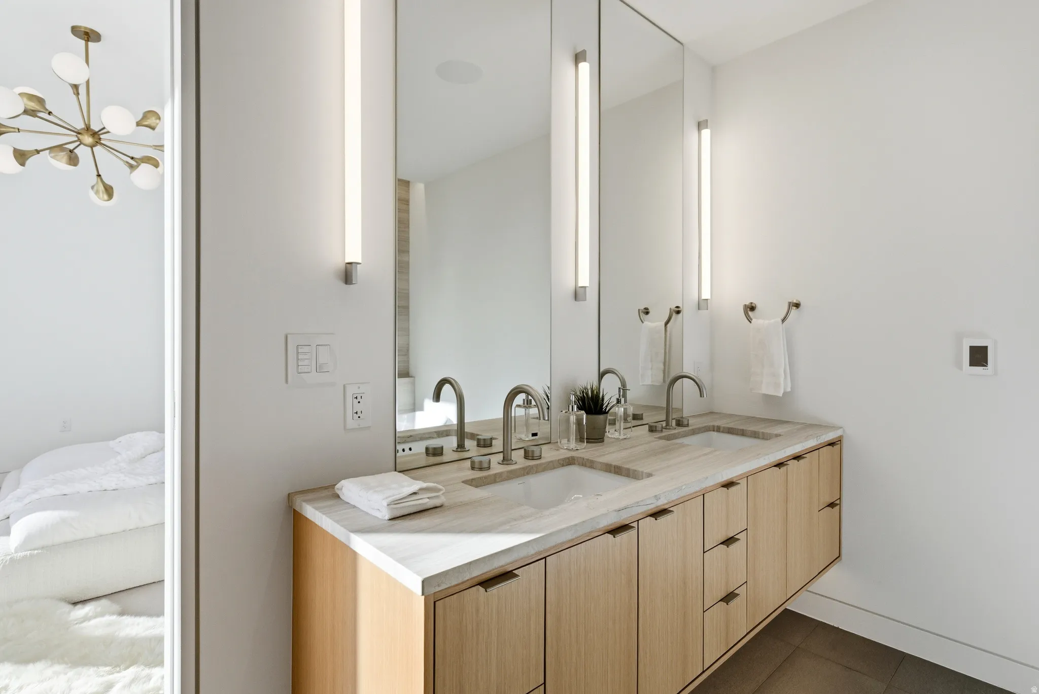 Floating double vanity with integrated sinks, stone countertop, and wood-finish cabinetry