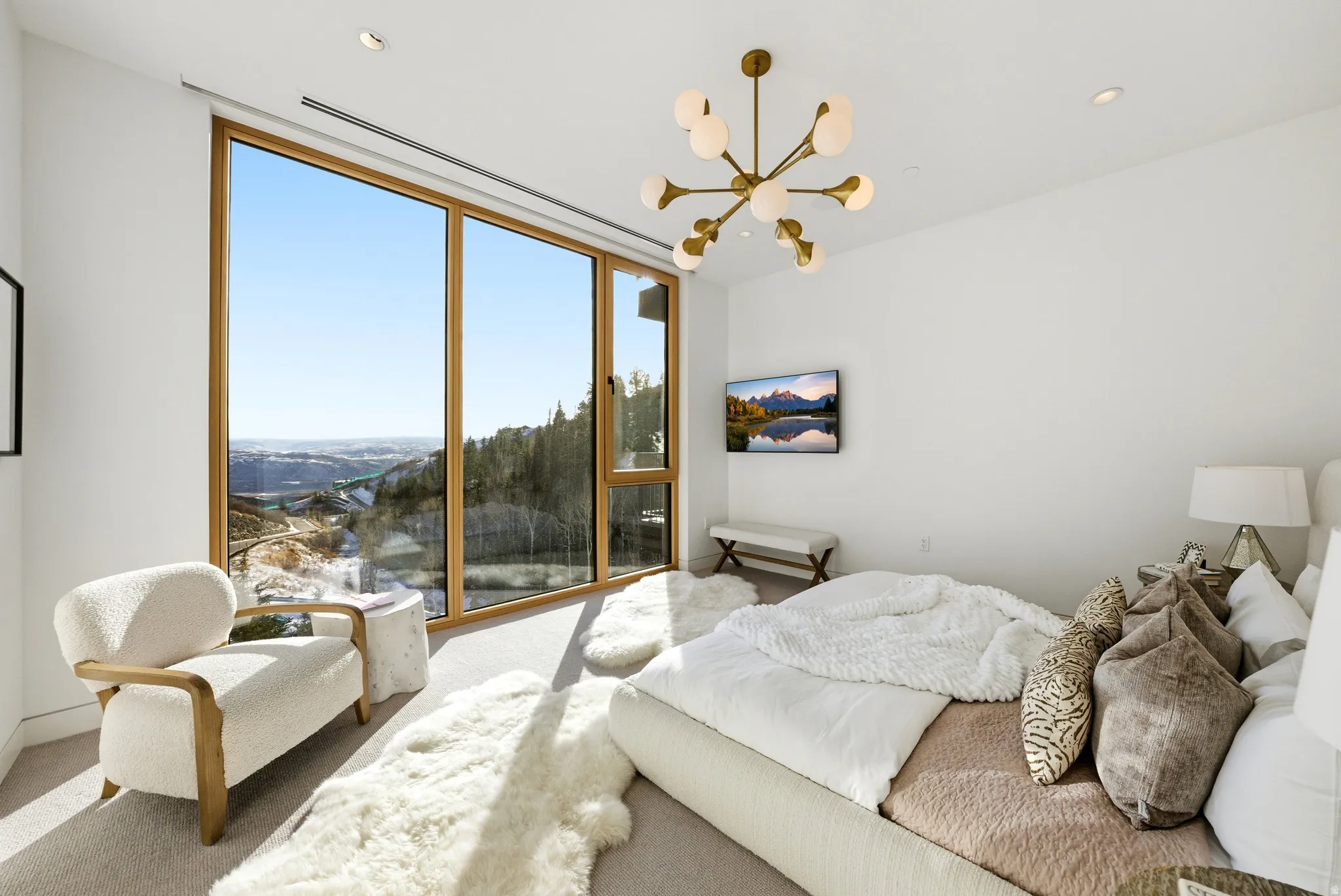 Floor-to-ceiling windows with natural wood frames, recessed ceiling lighting, a modern chandelier, and light-colored carpeting