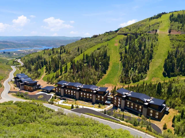 Modern multi-story structures featuring dark roofs and warm wood-tone siding