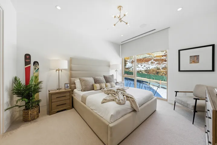 Bedroom featuring neutral-toned carpeting, recessed lighting, and a modern chandelier